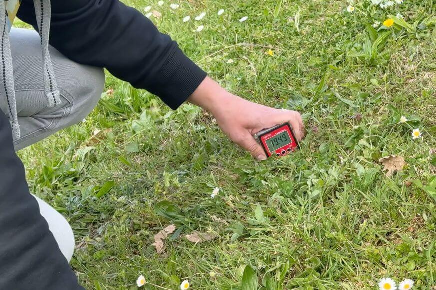 Ein Messgerät liegt im Test auf einem Gartenhang zur Messung der Neigung